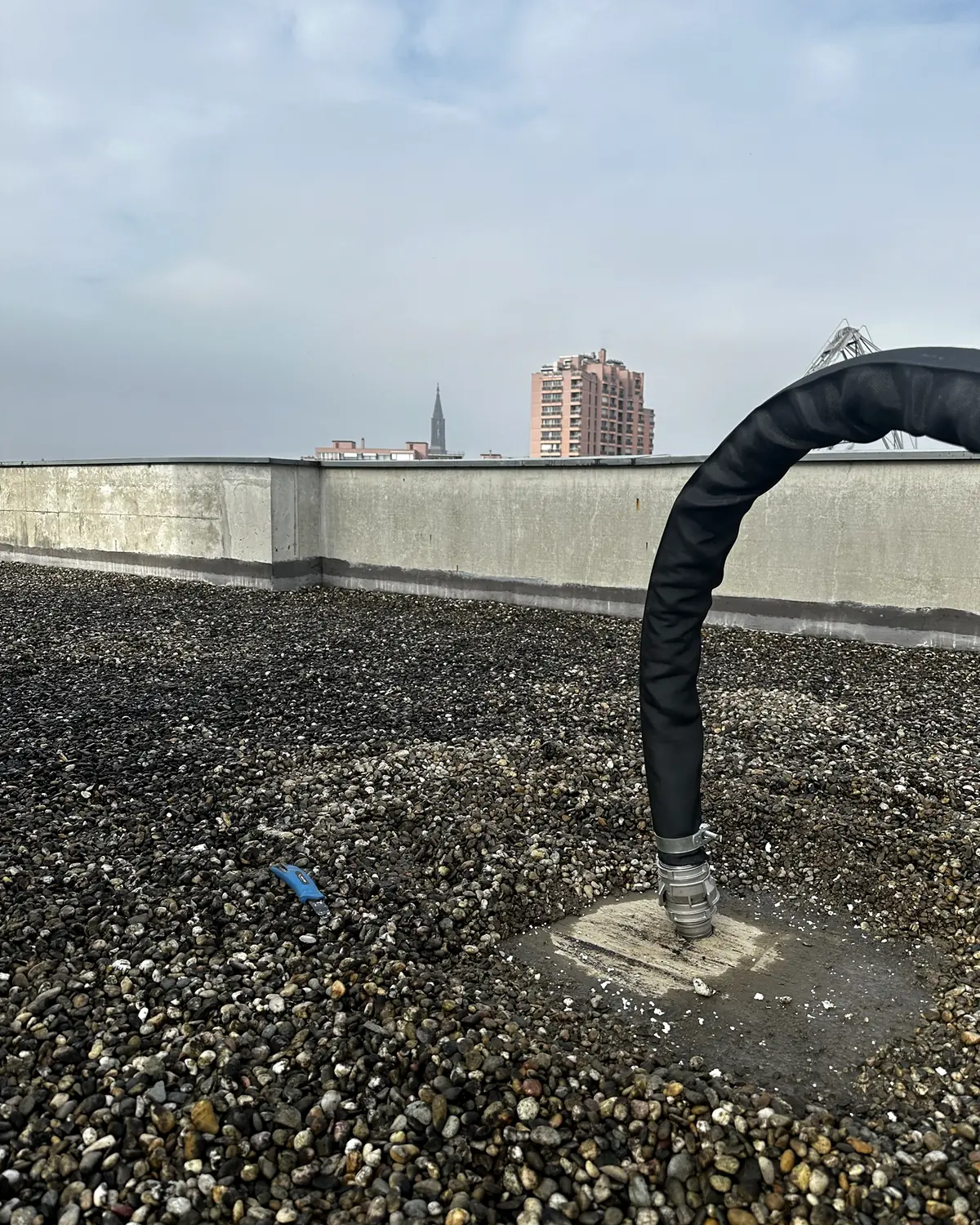Injection de fumée sous l'étanchéité d'une toiture-terrasse à Strasbourg, flèche de la cathédrale en arrière-plan